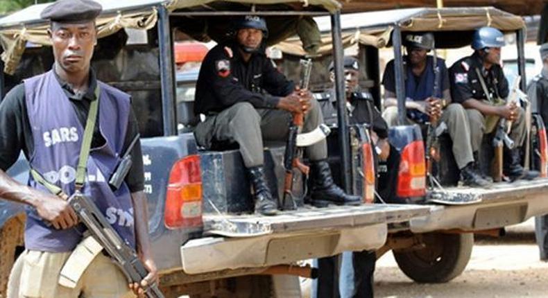 Nigerian police officers in patrol vans (Vanguard)