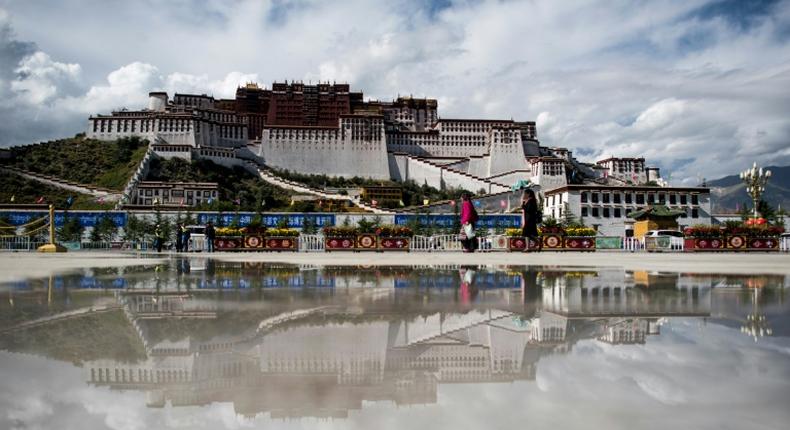 Tourists walk in front of the Potala Palace in the Tibetan capital of Lhasa in September 2016
