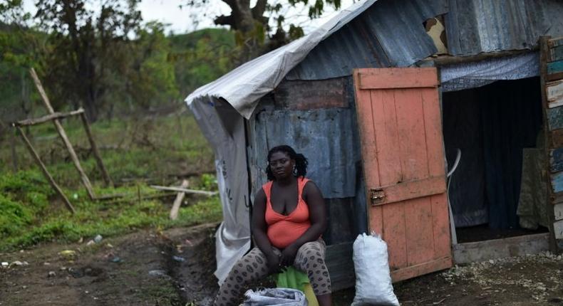 A woman displaced by Hurricane Matthew sits outside her house in the neighborhood of Gebeaux in the commune of Jeremie, southwestern Haiti, on October 22, 2016