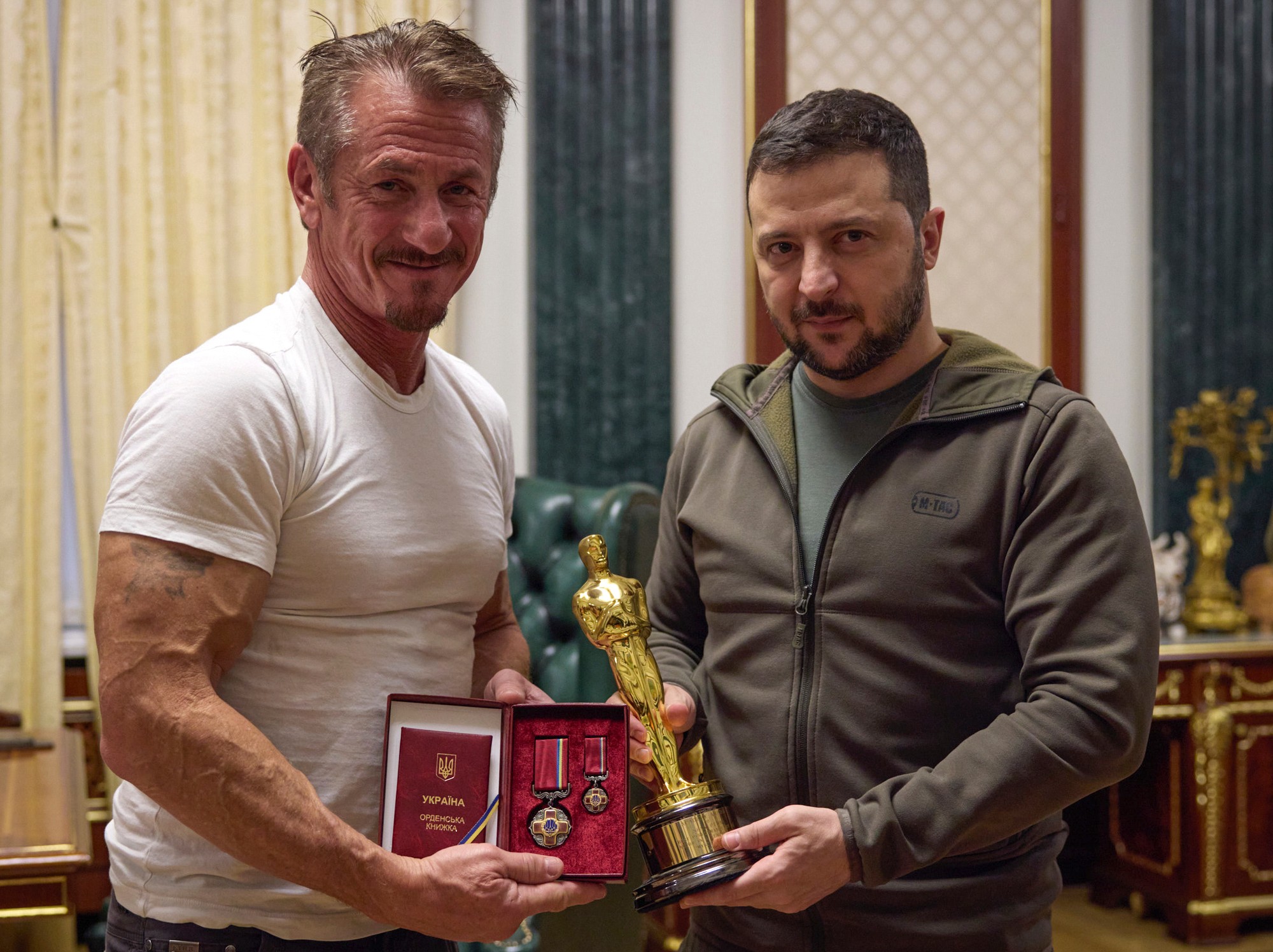 Ukrajinský prezident Volodymyr Zelenskyj (vľavo) a americký herec Sean Penn pózujú so soškou Oscara a ukrajinským vysokým štátnym vyznamenaním.