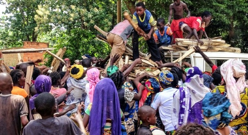 Central African internal-displaced people gather around a truck where volunteers distribute fire wood in Bangassou. At least 108 people were slaughtered and 76 injured during an attack by several hundred fighters on the town on May 13