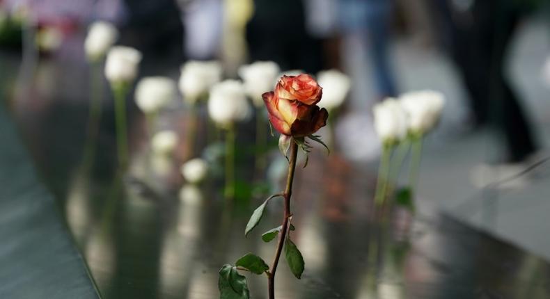 People leave flowers during the September 11 Commemoration Ceremony at the 9/11 Memorial at the World Trade Center on September 11, 2019,in New York.