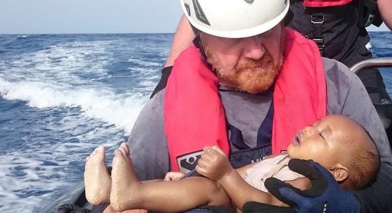 A German rescuer from the humanitarian organisation Sea-Watch holds a drowned migrant baby, off the Libyan cost May 27, 2016. 