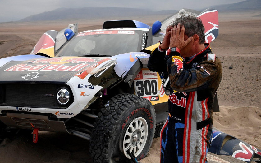 Driver Carlos Sainz, of Spain, and co-driver Lucas Cruz, of Spain, work on their Mini after it broke