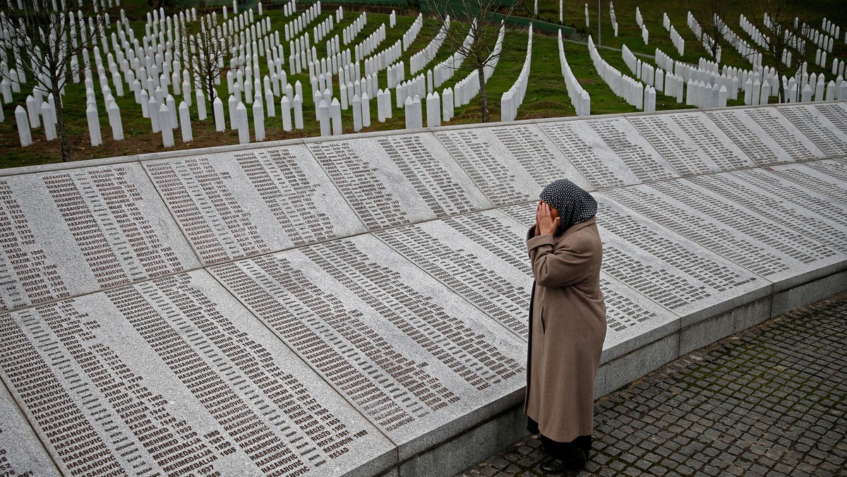 Bida Smajlovic, prays near the Memorial plaque with names of killed in Srebrenica massacre before wa