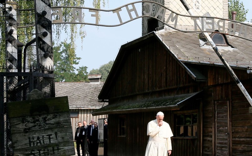 Franciszek pieszo, w samotności i ciszy, przeszedł przez historyczną bramę z napisem "Arbeit Macht Frei" i wszedł na teren byłego niemieckiego obozu Auschwitz I.Franciszek jest trzecim papieżem po Janie Pawle II i Benedykcie XVI, który przekroczył historyczną bramę obozową. Ojciec święty po wejściu do byłego obozu wsiadł do pojazdu elektrycznego, który wiezie go alejkami obozowymi do bloku 11. Na trasie przejazdu znalazł się m.in. plac, na którym 75. lat temu odbył się apel, podczas którego ojciec Maksymilian Kolbe dobrowolnie zgodził się oddać życie za współwięźnia.W bloku 11, przed którym Niemcy rozstrzelali tysiące osób, papież spotka się z kilkunastoma byłymi więźniami. Przed blokiem na gościa czeka premier Beata Szydło. Brama główna w byłym Auschwitz I, jako jedyna w całym obozie, została wykonana na rozkaz Niemców przez polskich więźniów politycznych. Jest jednym z najbardziej rozpoznawalnych symboli tego miejsca. Napis nad bramą "Arbeit Macht Frei" ("Praca czyni wolnym") pochodzi od tytułu XIX-w. powieści niemieckiego pisarza i pastora Lorenza Diefenbacha. Stanowił on parafrazę cytatu z Ewangelii św. Jana "Prawda czyni wolnym". Niemcy umieścili napis nad wejściem do kilku obozów, m.in. w Dachau, Sachsenhausen, Flossenbuerg i Gross-Rosen. Miał zapewniać to porządku panującym w obozie i dawać więźniom złudną nadzieję, że dzięki wytężonej pracy odzyskają wolność.