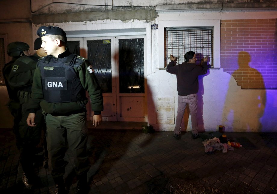 Members of Argentina’s gendarmerie, which took control of security in parts of Rosario city in 2014 after a spike in violence in drug-infested neighborhoods, stand guard next to a person near the Villa Banana slum in Rosario, September 10, 2015.