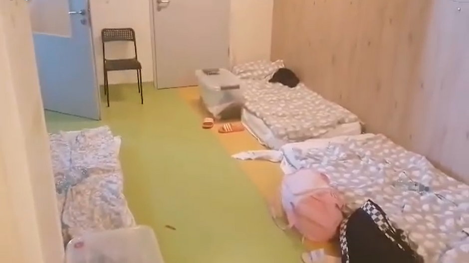 Dzieci leżą na materacach na korytarzu