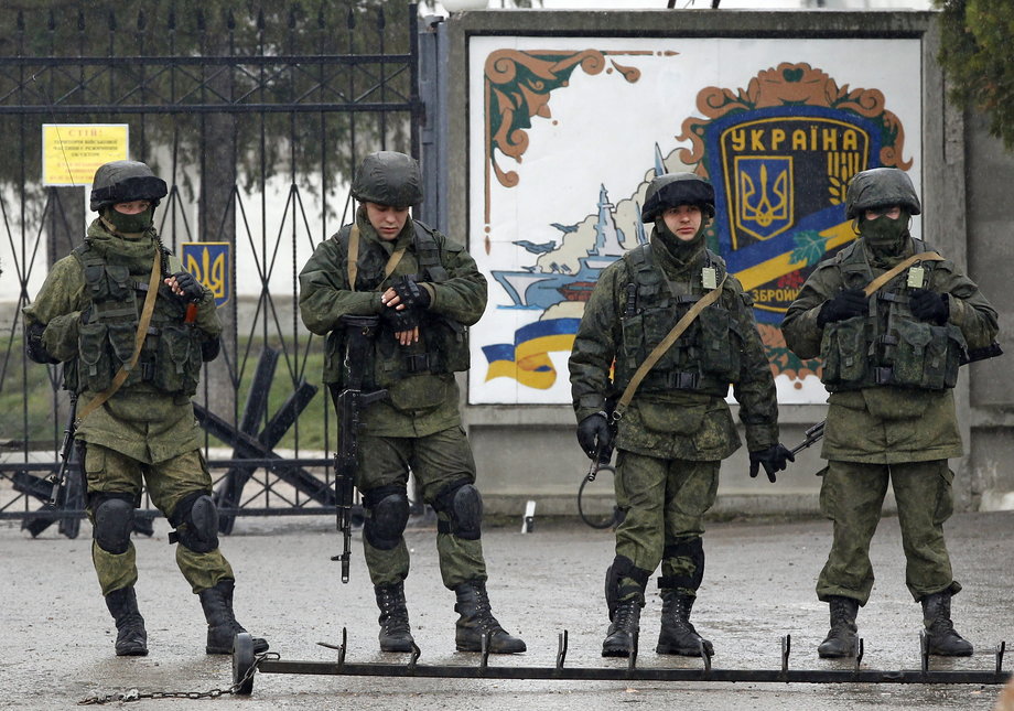 Uniformed men, believed to be Russian servicemen, stand guard outside a Ukrainian military base in the village of Perevalnoye, in March 2014.