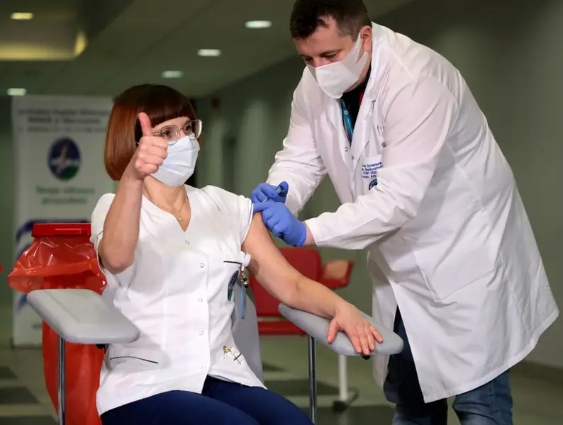 Alicja Jakubowska, naczelna pielęgniarka CSK MSWiA, która zaszczepiła się jako pierwsza w Polsce i dr Artur Zaczyński, który wykonał szczepienie. / Fot. Piotr Molecki/East News, Warszawa, 27.12.2020. Centralny Szpital Kliniczny MSWIA. Pierwsze szczepienia w ramach realizacji Narodowego Programu Szczepień przeciw Covid-19.