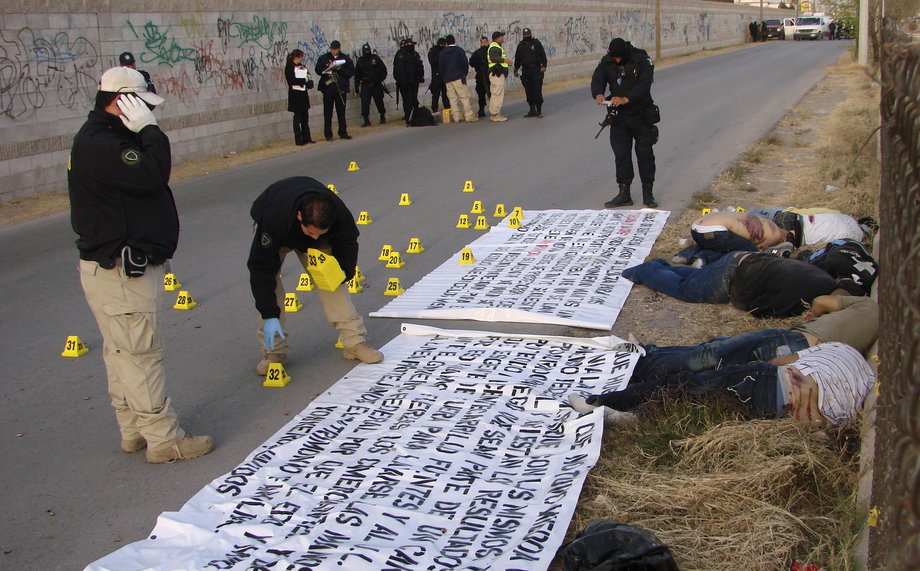 Police work at a crime scene where seven bodies were found in Ciudad Juarez, northern Mexico, November 25, 2008. The bodies of seven men with signs of torture and bullet wounds were found along side three banners threatening rival gangs, according to local media.