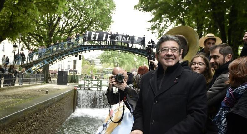 French presidential election candidate for the far-left coalition La France insoumise Jean-Luc Melenchon (L), stands aboard an unbowed barge on the Canal Saint-Martin on April 17, 2017 in Paris
