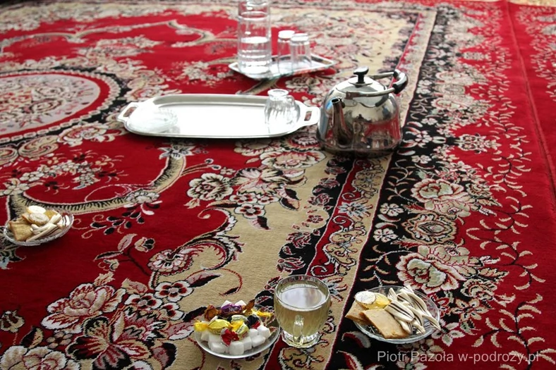 Zielona herbata i słodkości podane podczas rozmowy z Sahilem na dywanie w pokoju gościnnym