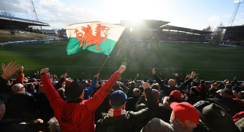 Wrexham fans celebrate a goal at the Racecourse Ground Creator: OLI SCARFF