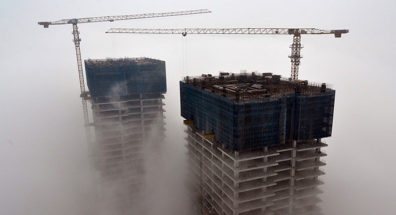 Buildings under construction are seen among fog in Rizhao, Shandong province, China.Reuters/Stringer