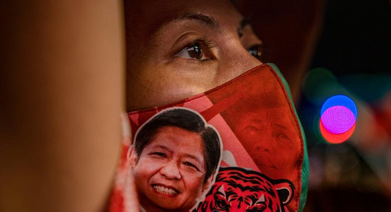 A supporter wears a face mask bearing a portrait of Ferdinand Bong Bong Marcos Jr.