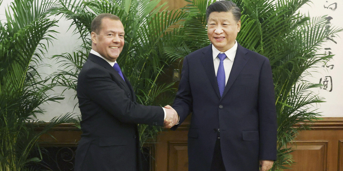 Prezydent Chin Xi Jinping i Dmitrij Miedwiediew podają sobie ręce podczas spotkania w Pekinie, 21 grudnia 2022 r.