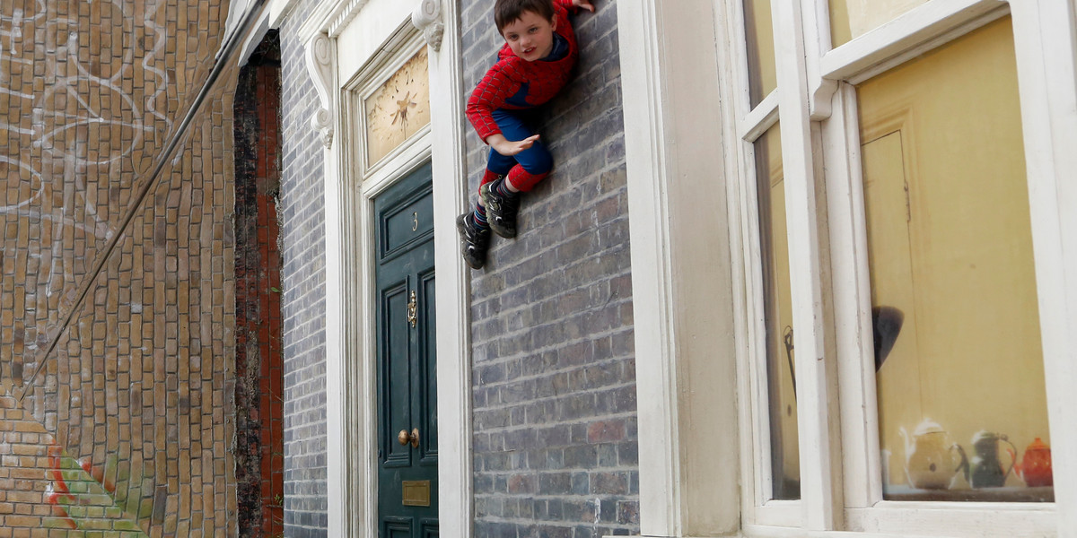 A child poses on Argentine artist Leonardo Erlich's optical illusion installation "Dalston House" in east London.