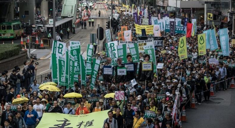 Protesters including pro-democracy lawmakers Lau Siu-lai (bottom C), Edward Yiu (behind Lau) and Nathan Law (bottom L) carry a banner reading Sovereignty belongs to the people! during a New Year's Day rally in Hong Kong on January 1, 2017