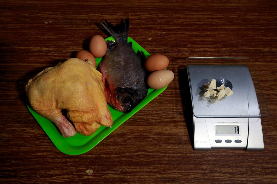 Chicken, fish, and eggs lie next to coca paste worth $14,000 Colombian pesos at a local store in Guyabero Region, Guaviare, Colombia.