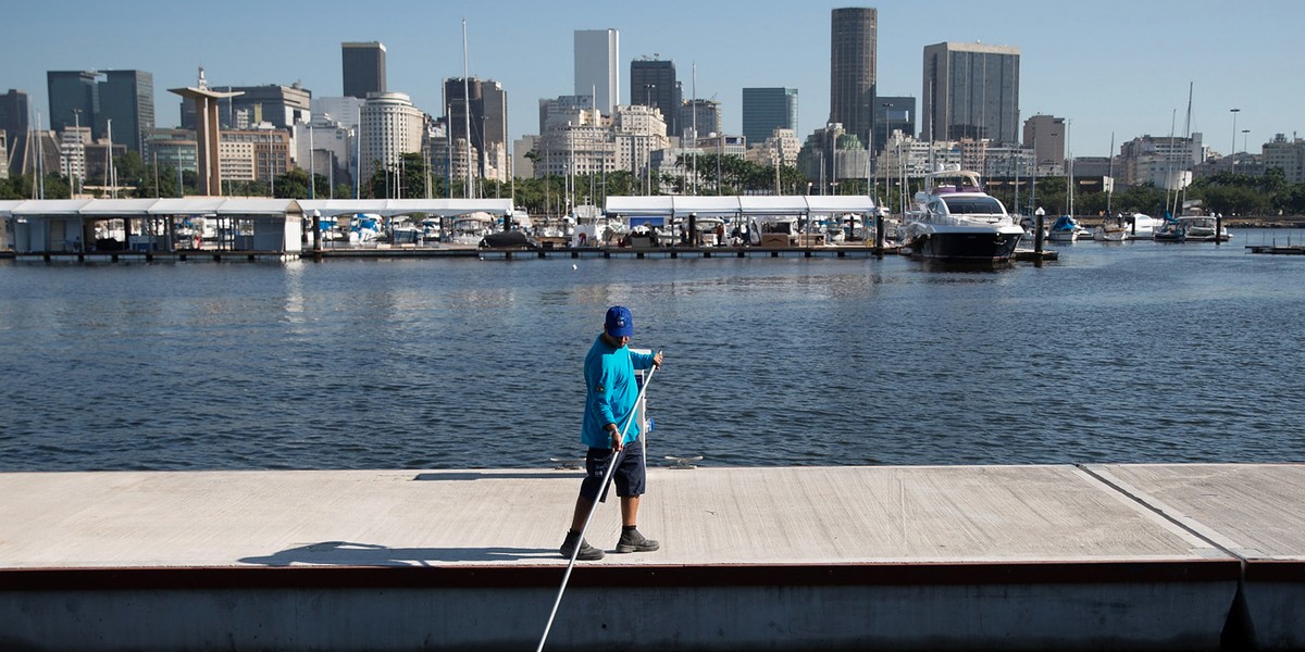 A worker collects trash from Guanabara Bay, in Rio.