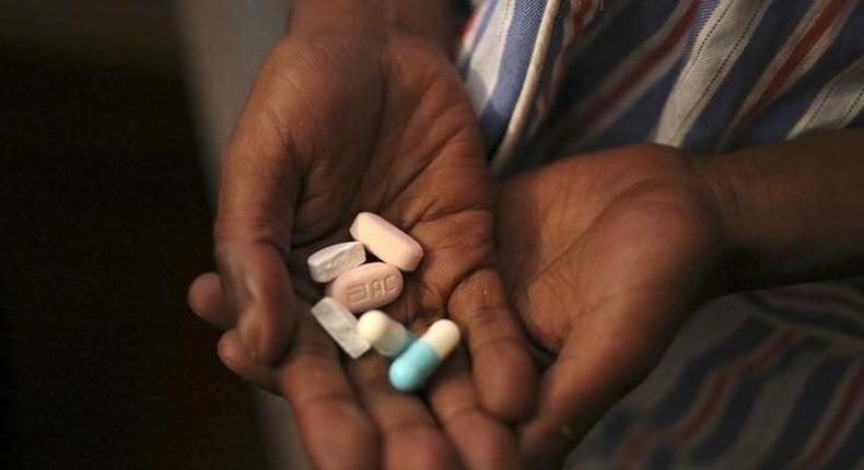 Nine-year-old Tumelo shows off antiretroviral (ARV) pills before taking his medication at Nkosi's Haven, south of Johannesburg November 28, 2014. REUTERS/Siphiwe Sibeko