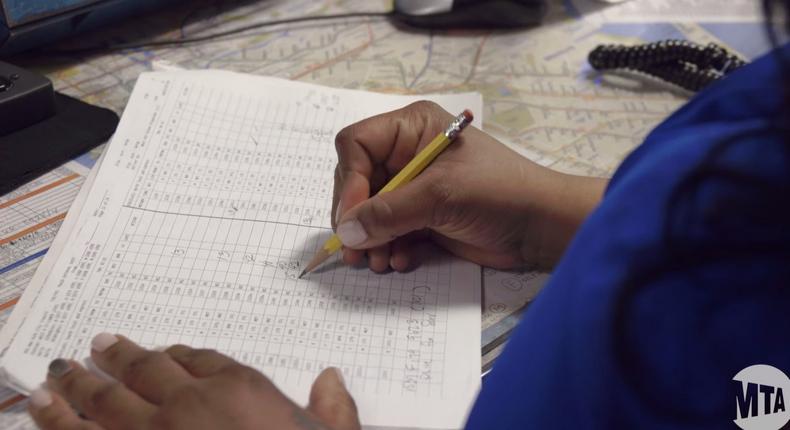 An MTA employee tracks trains by hand.