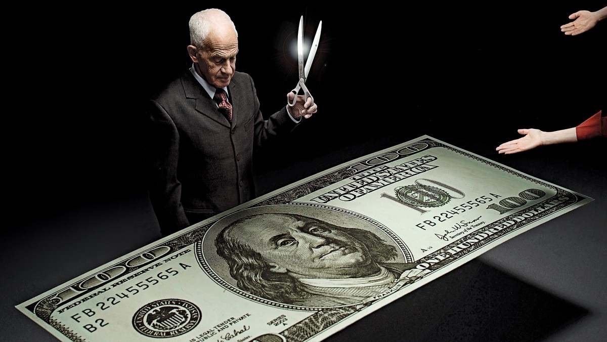 Businessman holding scissors and reaching hands around one hundred dollar bill