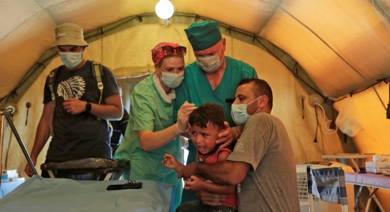 Medics treat a patient at a Russian field hospital set up in Beirut's largest sports stadium