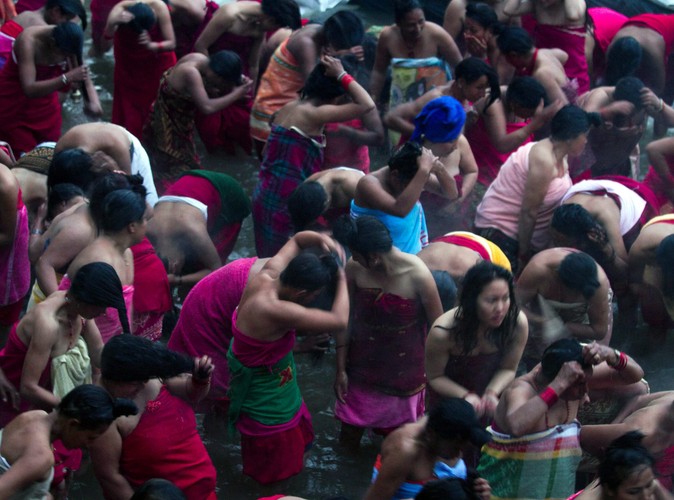 Kobiety uczestniczą w rytualnej kąpieli w rzece Salinadi w czasie obchodów święta Madhav Narayan w Sankhu, starożytnej wiosce niedaleko Katmandu