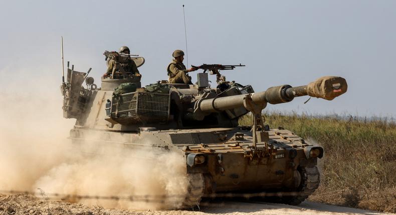 Israeli soldiers ride atop an artillery unit near the Israeli side of the border between Israel and the Gaza Strip, November 3, 2023.REUTERS/Amir Cohen