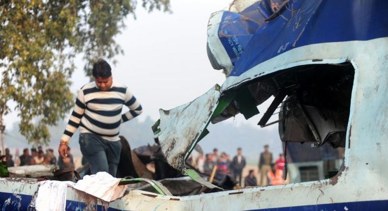 A relative attempts to identify luggage of a family member who was killed when a train derailed near Kanpur in the northern Indian state of Uttar Pradesh on November 20, 2016