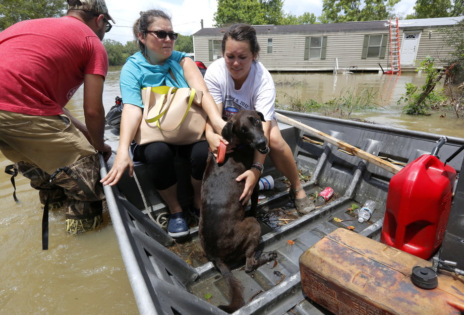 Brittany Addox (R) comforts her dog, Maggie, after being rescued in Ascension Parish, Louisiana.