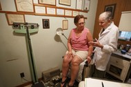 Dr. Bryon Harbolt examines patient Barbara Kilgore in his Cathedral Canyon Clinic in Altamont