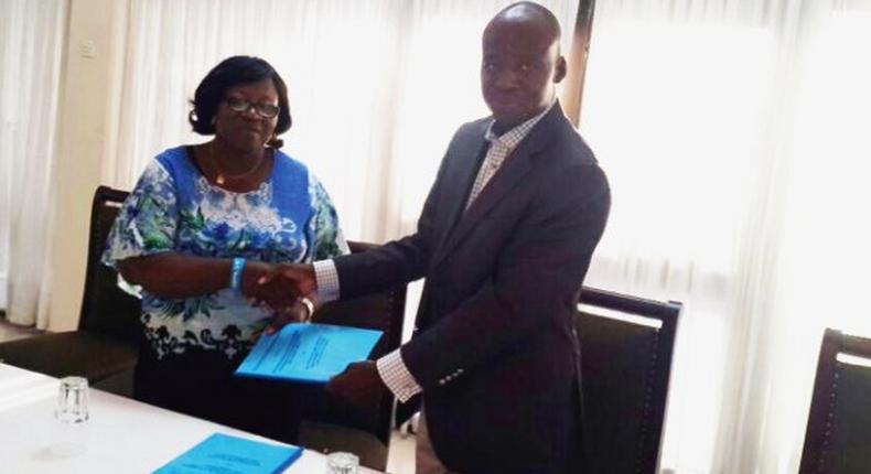 Dr H.N. Akubuiro, (left) the Vice-President of the council of the Chartered Institute of Loans and Risk Management, Nigeria, presenting the memorandum of understanding to Mr Adam Sulley, the President of the Institute of Loans and Risk Management, Ghana