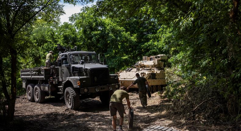 Soldiers and mechanics from Ukraine's 47th Mechanized Brigade go to change the wheels and tracks of a damaged US made Bradley Fighting Vehicle at a secret workshop in a wooded area in Zaporizhzhia Region, Ukraine.Ed Ram/For The Washington Post via Getty Images