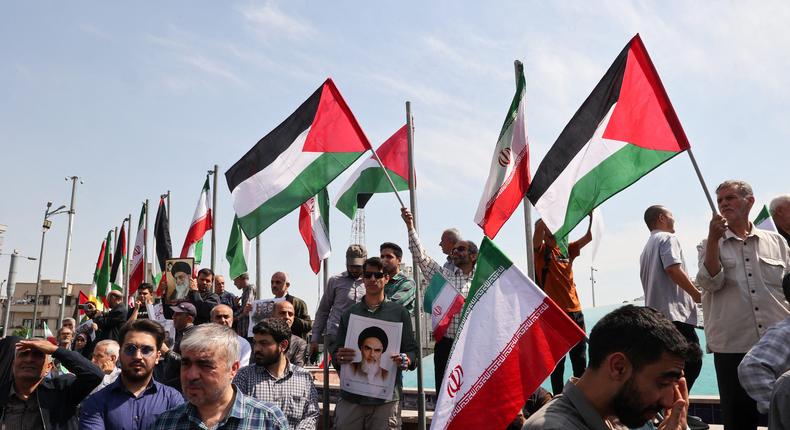 Iranians wave the flags of Palestine and Iran they gather during an anti-Israel demonstration after the Friday noon prayer in Tehran on April 19, 2024. ATTA KENARE/AFP via Getty Images