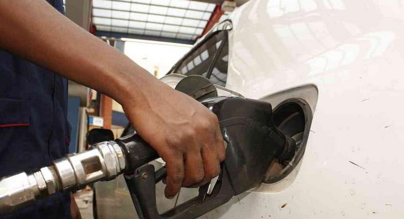 A petrol station attendant fuelling a car