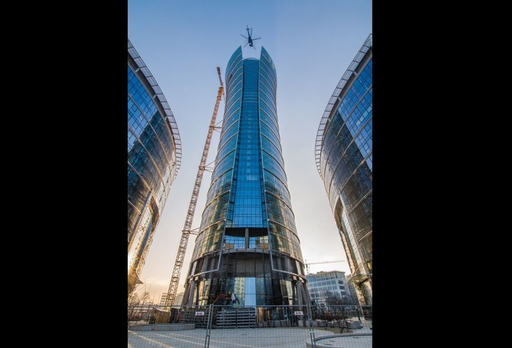 Zamontowanie ogromnych iglic było skomplikowaną operacją logistyczną, w której konieczne było wykorzystanie specjalistycznego sprzętu i helikoptera. Każda iglica została podzielona na 12 segmentów. Elementy, jeden po drugim, były podnoszone helikopterem z placu rozładunkowego, podniesione powyżej dachu budynku i precyzyjnie opuszczane na odpowiednie miejsce.