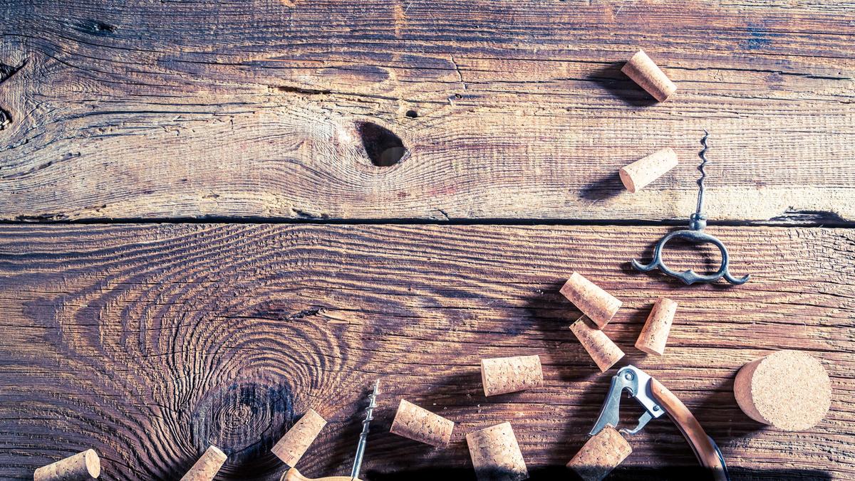 Corks from wine and opener on wooden table