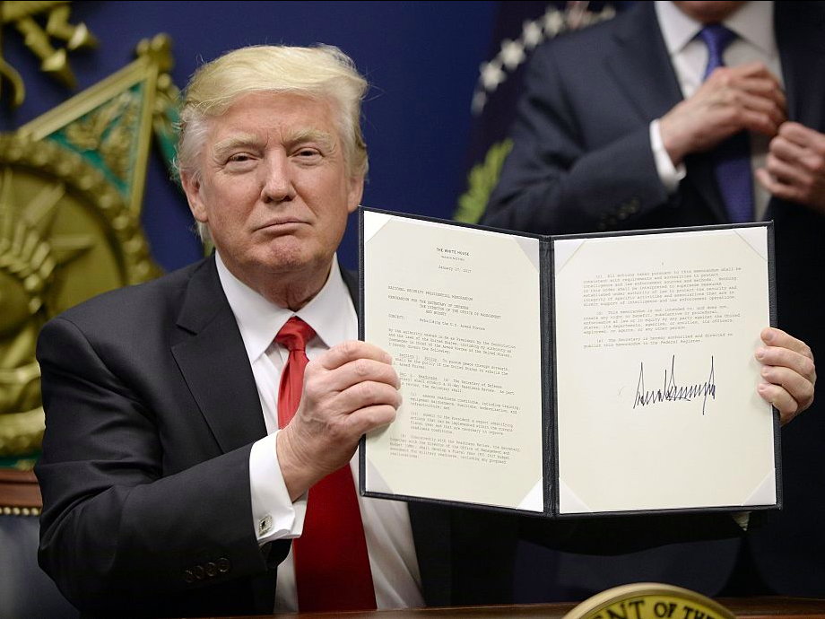 President Donald Trump signs the executive order barring immigrants from some Muslim-majority countries from entering the US.