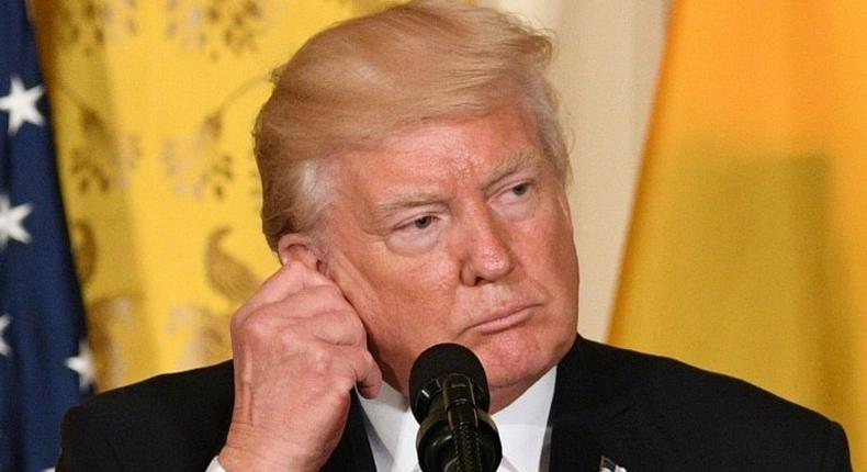 US President Donald Trump adjusts his translation ear piece during a joint press conference with Colombia's President Juan Manuel Santos at the White House on May 18, 2017 in Washington, DC