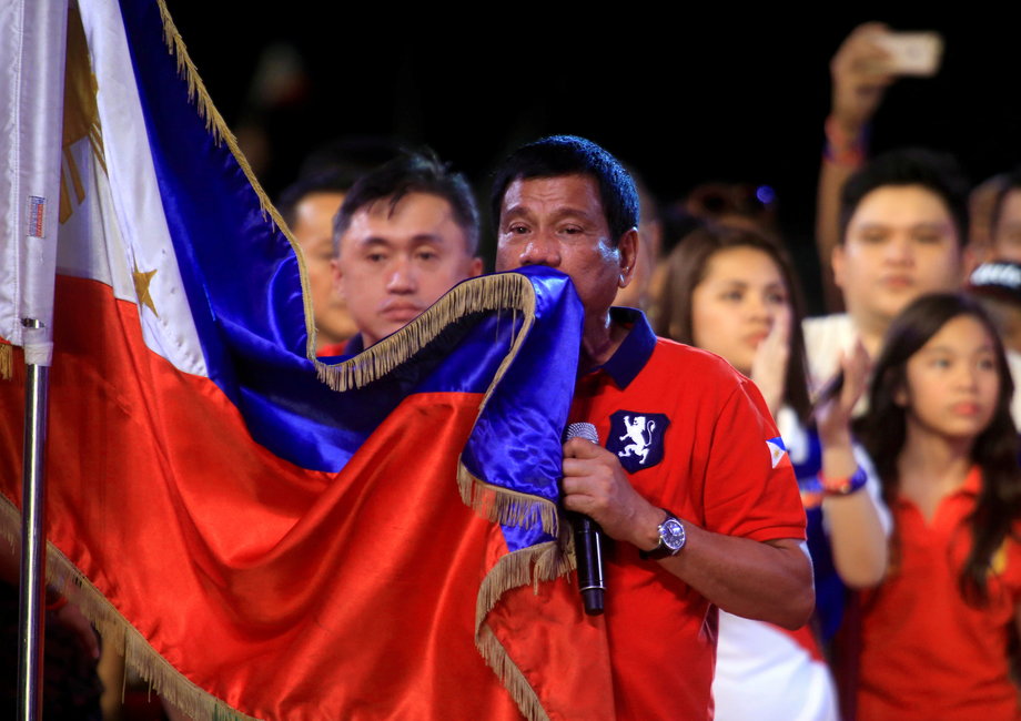 Philippine presidential candidate and Davao City mayor Rodrigo "Digong" Duterte kisses the Philippine flag during a campaign rally before the national elections at Rizal park in Manila, May 7, 2016.