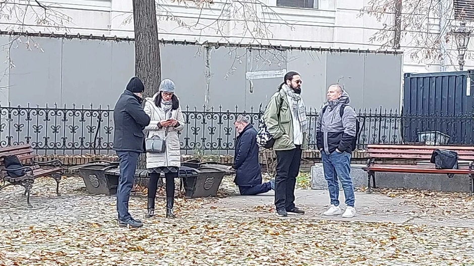 Direktor gimnazije kleči, u pozi kao da se moli