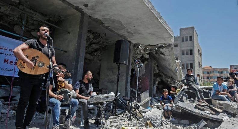 The Palestinian band Dawaween performs on May 14, 2019 on the rubble of a building in the Gaza Strip that was recently destroyed by Israeli air strikes during an event calling for a boycott of the Eurovision song contest hosted by Israel