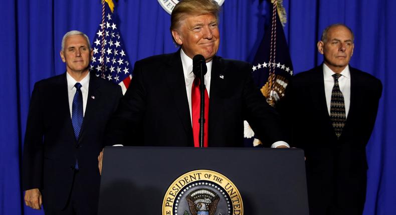 President Donald Trump (C), flanked by Vice President Mike Pence (L) and Homeland Security Secretary John Kelly (R), delivers remarks at Homeland Security headquarters on January 25, 2017.
