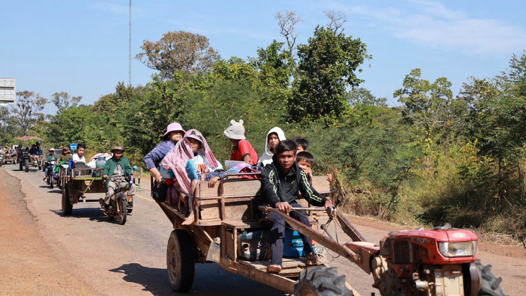 Dedinčania sedia na traktoroch, keď utekajú zo svojho domu v provincii Preah Vihear na severe Kambodže v pondelok 8. decembra 2025.