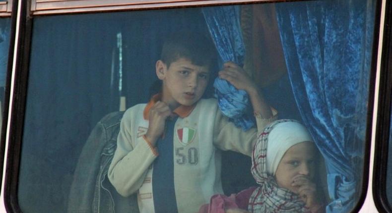 Syrian civilians being evacuated from the government-held towns of Fuaa and Kafraya, which have been under crippling siege for more than two years, on buses near the rebel-held transit point of Rashidin on April 19, 2017