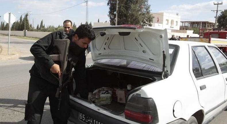 A police officer checks the back of a car at a checkpoint near the police headquarters in western Kasserine region October 23, 2014, as part of security measures ahead of the country's parliamentary elections on Sunday. REUTERS/Zoubeir Souissi