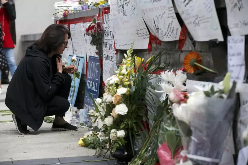 Kobieta zostawia kwiaty przy symbolicznych tablicach rozstawionych na Yonge Street, niedaleko miejsca ataku terrorystycznego z 24 kwietnia 2018 r. w Toronto / Cole Burston, Getty Images